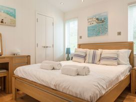 A bedroom with a bed and dresser at 2 Tree Tops in Lanreath