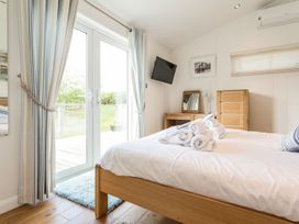 A bedroom with a bed and dresser at 2 Tree Tops in Lanreath