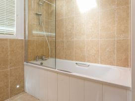 A bathroom with a bathtub and shower at 2 Tree Tops in Lanreath
