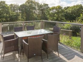 An outdoor seating area with a table and chairs at 2 Tree Tops in Lanreath