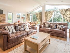 A living room with sofas and a coffee table at 2 Tree Tops in Lanreath