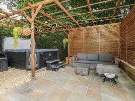 An outdoor area with a hot tub and a sofa at Charltons Hollow Cabin in Haywards Heath