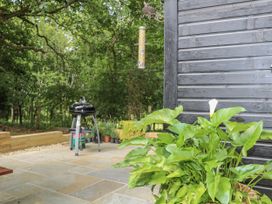 A garden area with a barbeque grill and plants at Charltons Hollow Cabin, Haywards Heath