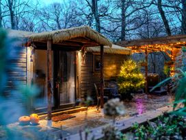 A cabin with pumpkins and a tree at Charltons Hollow Cabin in Bolney