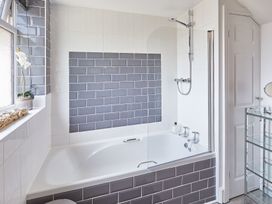 A bathroom with a bathtub and shower at Apartment 2 in Whitby