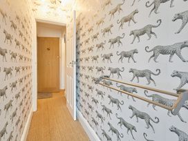 A hallway with patterned wallpaper and door at Apartment 2 in Whitby