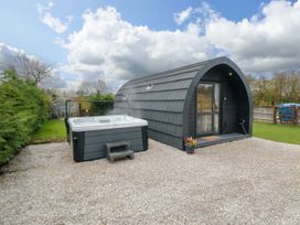 An outdoor area with a hot tub next to a glamping pod at Bumblebee Glamping Pod in Malton
