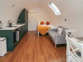A pod with kitchen units and bed at Bumblebee Glamping Pod in Malton