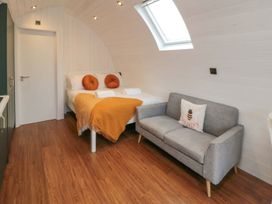 A bedroom with a bed and sofa at Bumblebee Glamping Pod in Malton