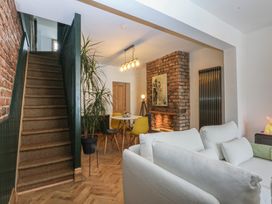 A living room with a staircase and a dining area at 5 Llewelyn Street Conwy