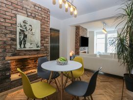 A dining room with a round table and chairs at 5 Llewelyn Street Conwy