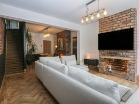 A living room with a sofa and television at 5 Llewelyn Street in Conwy