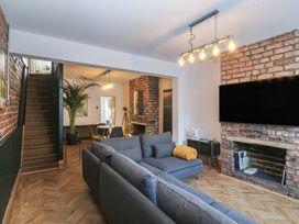 A living room with a sofa and television at Ty Gelert in Conwy