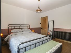 A bedroom with a bed and bedside tables at Ty Gelert in Conwy