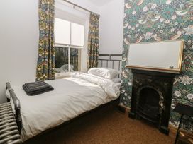 A bedroom with a bed and curtains at Ty Gelert in Conwy