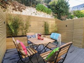 A garden area with a wooden table and chairs at Ty Gelert in Conwy