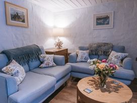 A living room with sofas and a flower vase at Tamarisk Cottage in St. Agnes