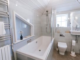 A bathroom with a bathtub, shower, toilet, and sink at Tamarisk Cottage in St. Agnes