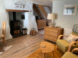 A living room with a fireplace and sofa at Tamarisk Cottage, St Agnes