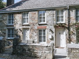 An outdoor view of a stone house with front door and windows at Bluck's cottage in St. Agnes