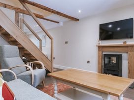 A living room with a staircase and fireplace at Bluck's cottage St. Agnes