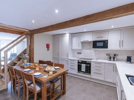 A kitchen with a dining table and appliances at Bluck's cottage in St. Agnes