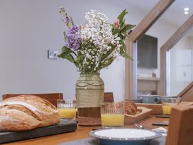 A dining room table with a flower vase juice and baked goods at Bluck's cottage in St. Agnes