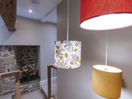 A staircase with hanging lights and a flower arrangement at Bluck's cottage St. Agnes