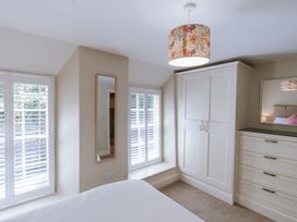 A bedroom featuring a wardrobe and a mirror at Bluck's cottage St. Agnes