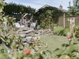 A garden with a sundial and chairs at Bluck's cottage St. Agnes