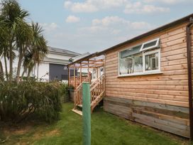 A wooden exterior of a building with stairs and palm trees at Big Bertha by the Sea Northam