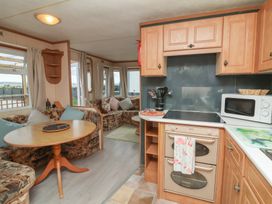 A kitchen with a table and chair set at Big Bertha by the Sea in Northam