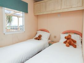 A bedroom with two beds and teddy bears on each at Big Bertha by the Sea in Northam