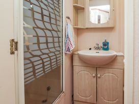 A bathroom with a shower and sink at Big Bertha by the Sea in Northam