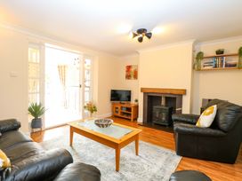 A living room with a table and sofa at Honeysuckle Cottage in Swaffham