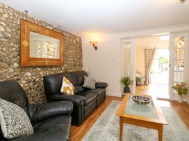 A living room with a sofa and coffee table at Honeysuckle Cottage in Swaffham