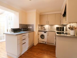 A kitchen with a washing machine and utensils holder at Honeysuckle Cottage in Swaffham