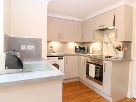A kitchen with cabinets and appliances at Honeysuckle Cottage in Swaffham