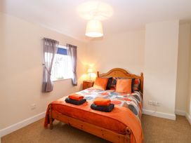 A bedroom with a bed and curtains at Honeysuckle Cottage in Swaffham