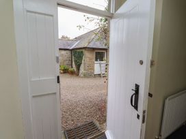 An entrance with an open door leading to a gravel garden at Honeymug in Branton near Powburn