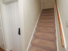 A staircase leading up with a door at the side at Honeymug in Branton near Powburn