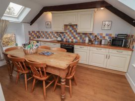 A kitchen with a dining table and chairs at Honeymug in Branton near Powburn