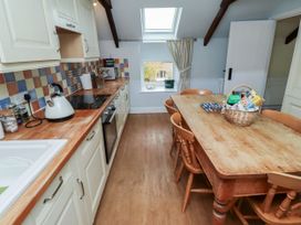 A kitchen with a dining table and cooking appliances at Honeymug in Branton near Powburn