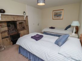 A bedroom with two beds and a fireplace at Honeymug Branton near Powburn