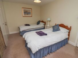 A bedroom with two single beds and a nightstand at Honeymug in Branton near Powburn