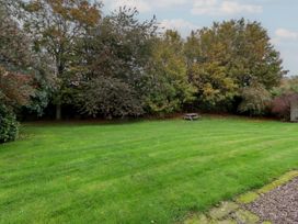 A garden with trees and a bench at Honeymug in Branton near Powburn