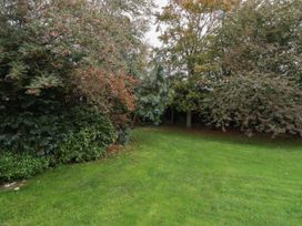 A garden with trees and grass at Honeymug in Branton near Powburn