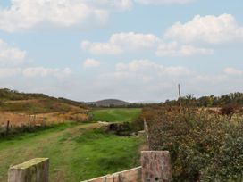 A grassy path with a fence and hills at Honeymug in Branton near Powburn