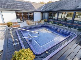 A hot tub with seating area and solar panels at Honeymug in Branton near Powburn
