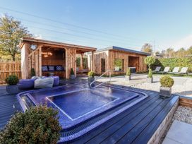An outdoor area with a hot tub and wooden structures at Honeymug in Branton near Powburn